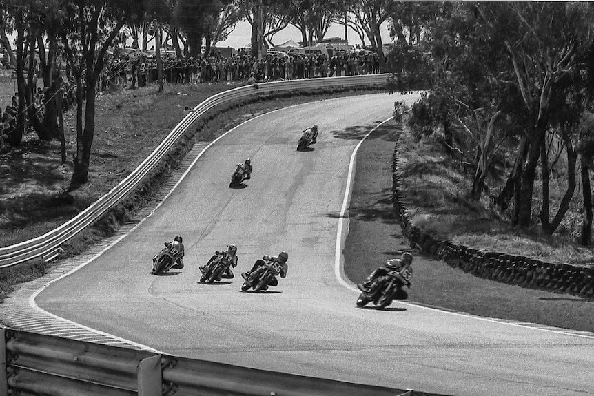 Black and white photograph of motorcycles racing at Mount Panorama, Bathurst, NSW