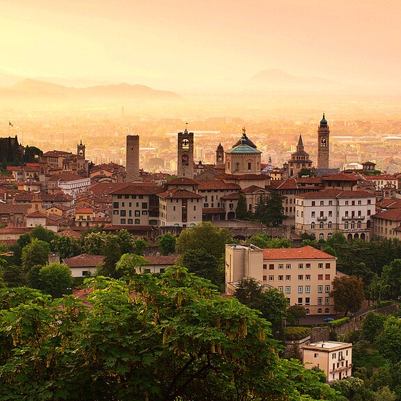Red roofs of the old city of Bergamo on a hill at sunrise.