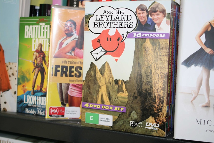 A close up of DVDs one with Ask the Leyland Brothers has the duo's photo and rocks in the foreground.