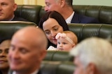 MP Brittany Lauga holds her baby daughter Odette in the chamber on the opening day of the 56th Queensland Parliament
