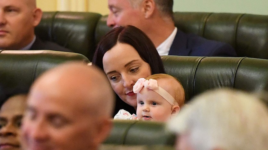 MP Brittany Lauga holds her baby daughter Odette in the chamber on the opening day of the 56th Queensland Parliament
