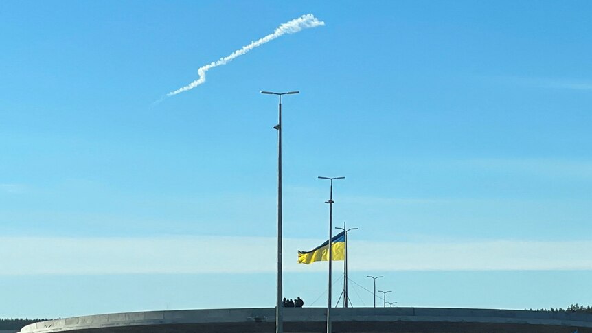 A missile trace above a Ukraine flag.