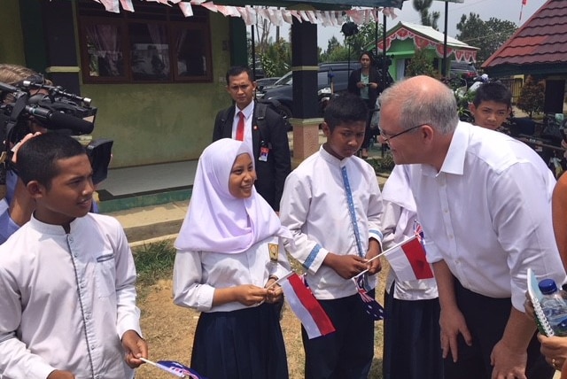 Scott Morrison talking to an Indonesian girl with a flag.