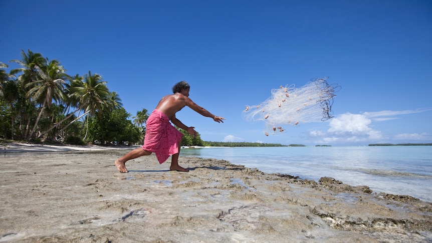 Fisherman casts net in Tuvalu