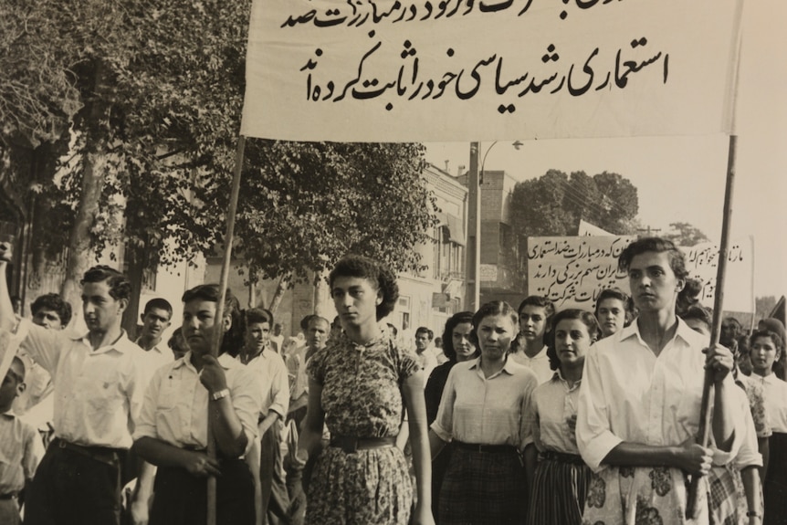 A black and white photo of a group of Iranians protesting for women's rights in the 1950s.