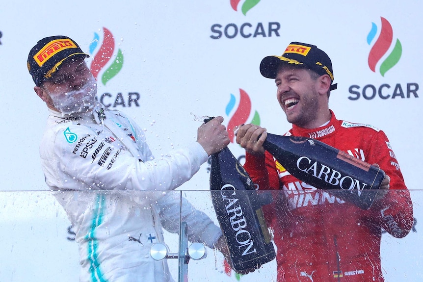 Valtteri Bottas is showered in champagne by Sebastian Vettel