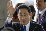 Japanese PM Fumio Kishida waves as he attends outdoor event.