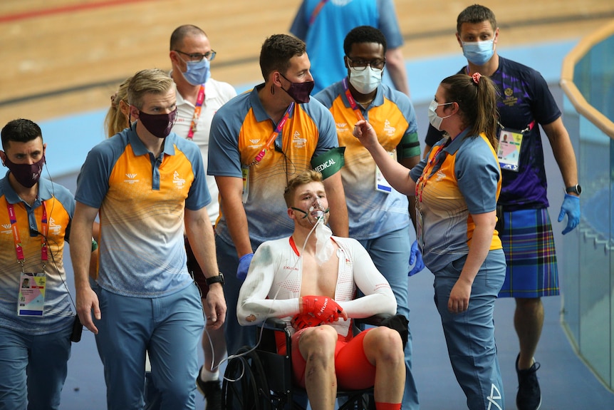 Joe Truman is pushed in a wheelchair with an oxygen mask over his face