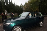 Prince Andrew and Prince Edward  can be seen inside a SUV driving along a road in scotland with people taking photos