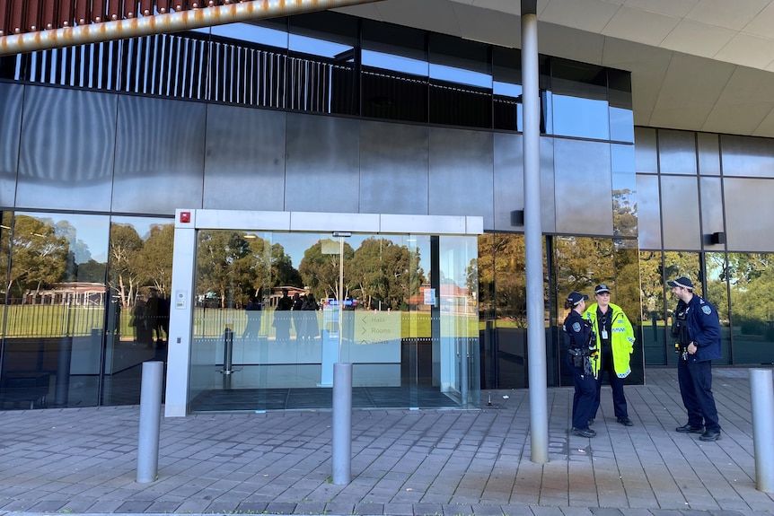 Police officers standing in front of a closed building