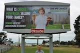 Tasmanian man Aaron Schultz stands in front of an anti-junk food billboard in Hobart.
