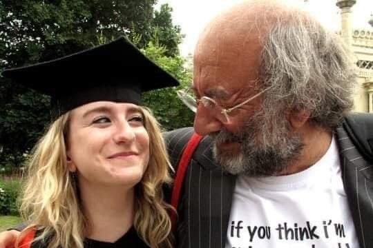 Jo Goodman wearing mortar board hat  and graduation gown is hugged by  her father Stuart Goodman, in a grey pin-striped jacket