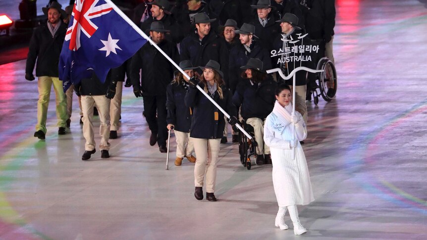 Joany Badenhorst carries the flag for Australia at the 2018 Winter Paralympics opening ceremony.