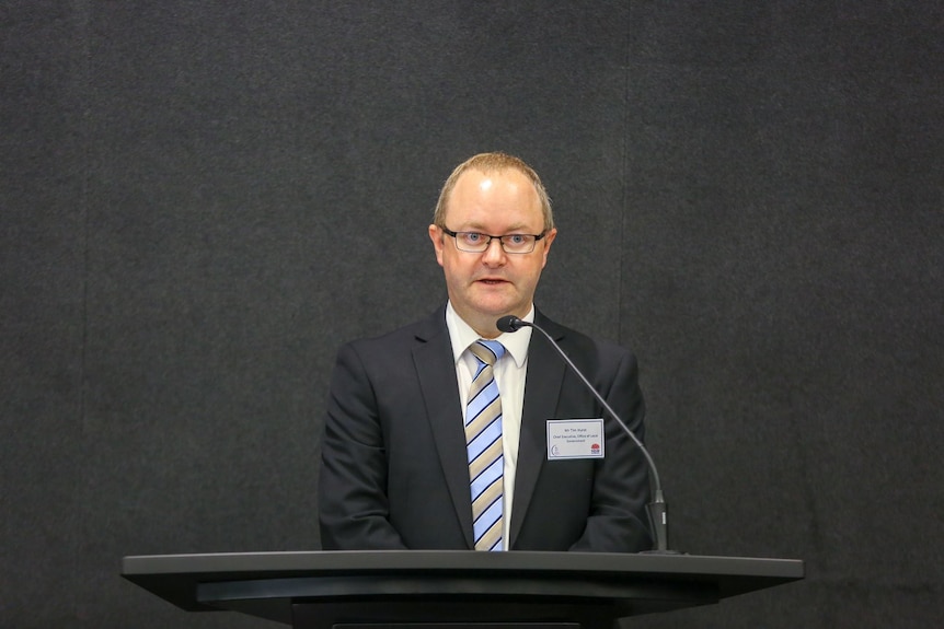 a man in a suit behind a podium