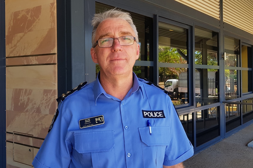 Allan Adams standing in front of a police station.