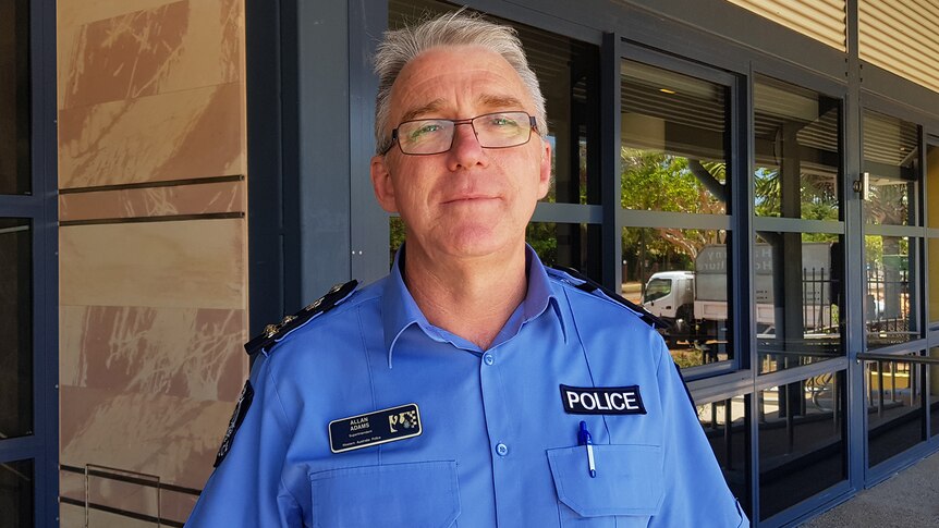 Allan Adams standing in front of a police station.