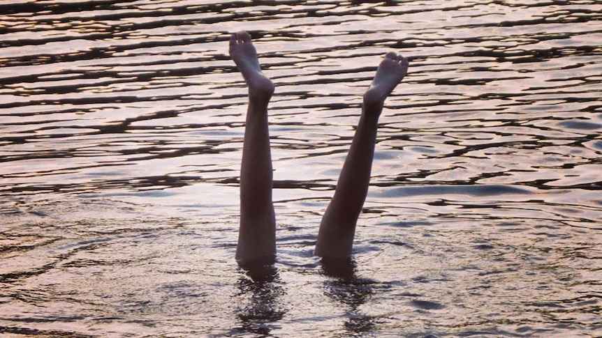 Person does handstand in water