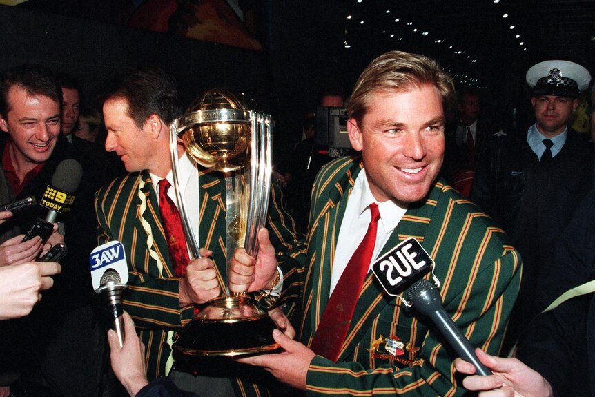 Shane Warne talks to reporters as he and Steve Waugh hold the Cricket World Cup trophy