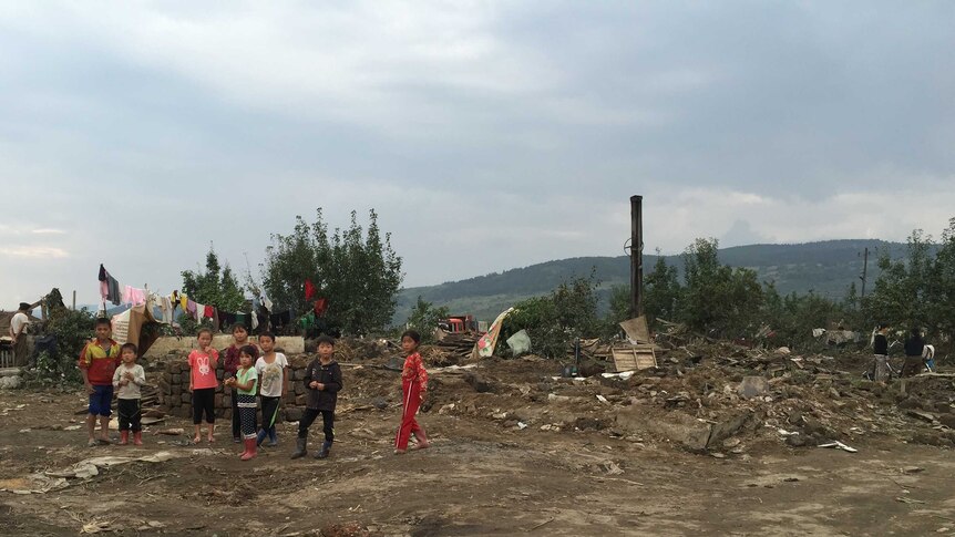 UNICEF DPRK handout showing children standing among building debris near flooding on the Tumen river in Hoeryong, in North Korea's North Hamyong Province