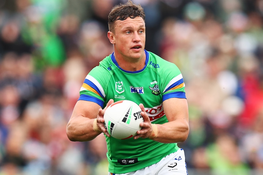 A Canberra Raiders NRL player runs with the ball in both hands.