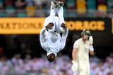Kevin Sinclair is upside down, mid backflip after taking a wicket