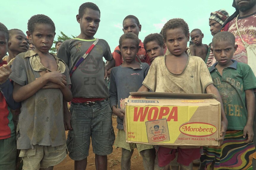 Children in Huiya village with a box of biscuits.