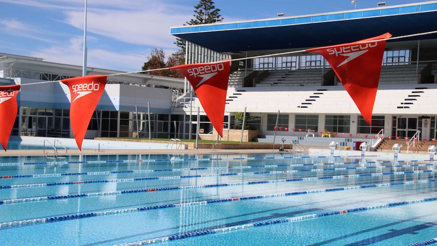 Flags hanging across a large swimming pool.