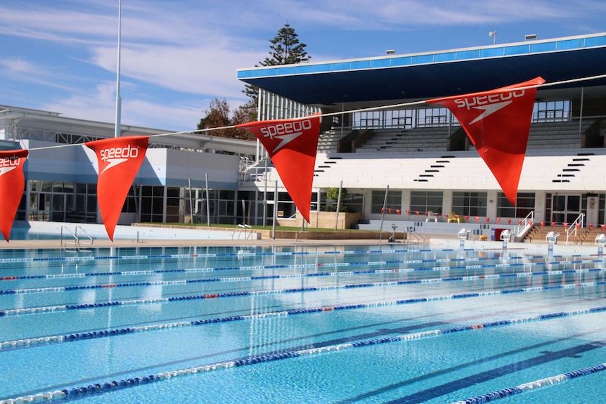 Flags hanging across a large swimming pool.
