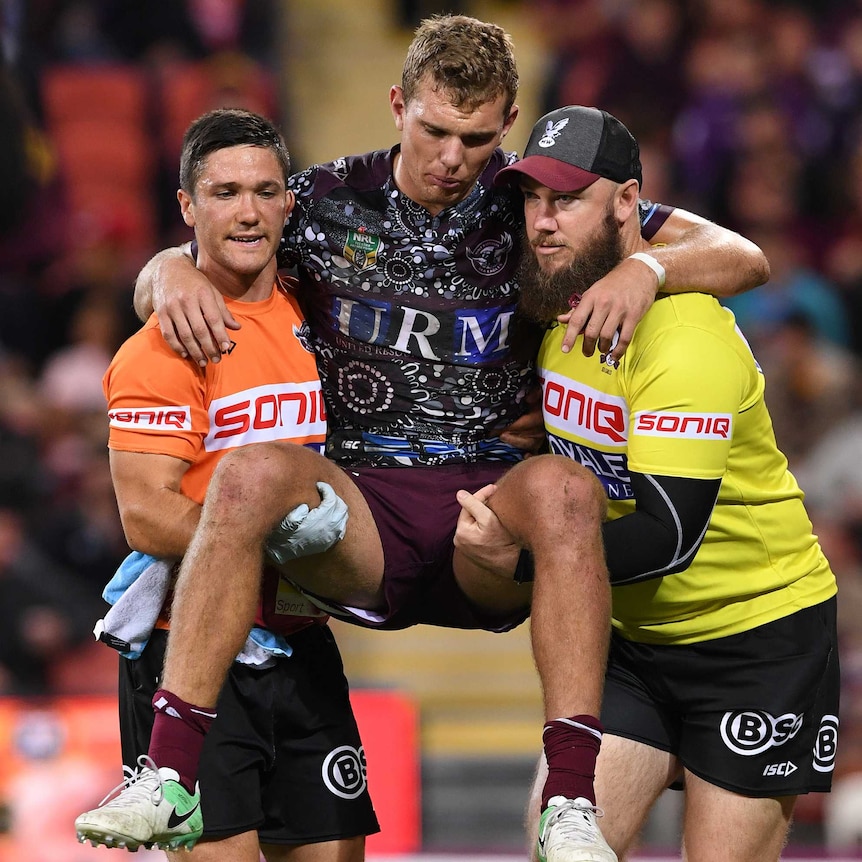 Tom Trbojevic carried from the field injured by Manly trainers