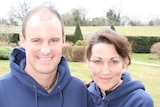 Andrew Strauss and wife Ruth stand arm in arm on a green lawn.