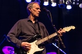 Tom Verlaine playing the guitar on stage in 2019