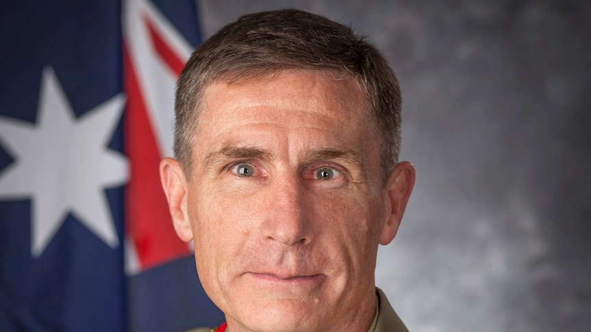 Angus Campbell, wearing his Army uniform, sits in front of a grey background and Australian flag.