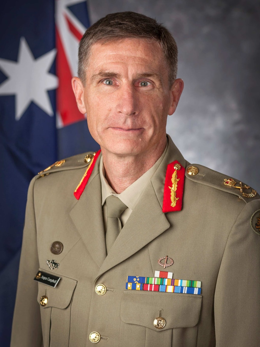 Angus Campbell, wearing his Army uniform, sits in front of a grey background and Australian flag.