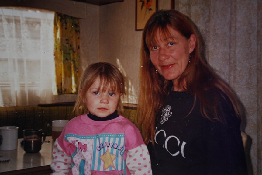 Old photo of a mother and daughter in a house.