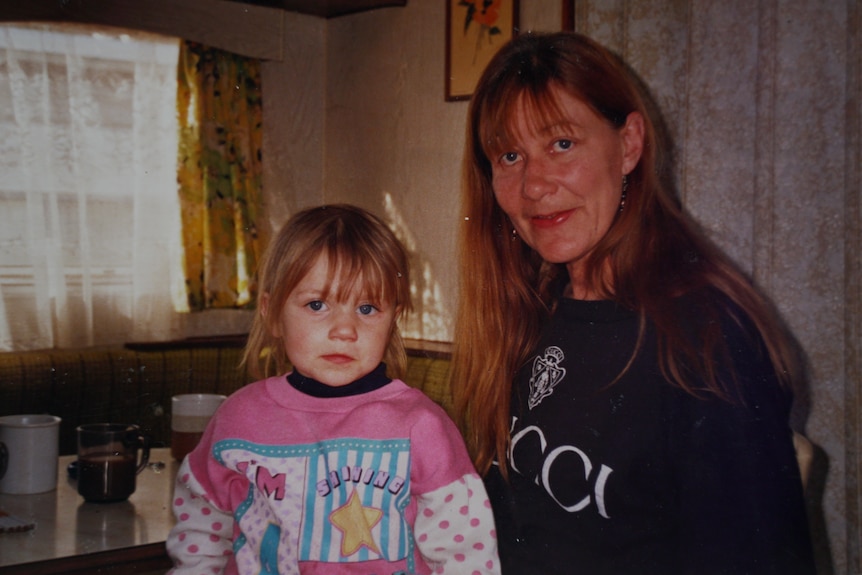 Old photo of a mother and daughter in a house.