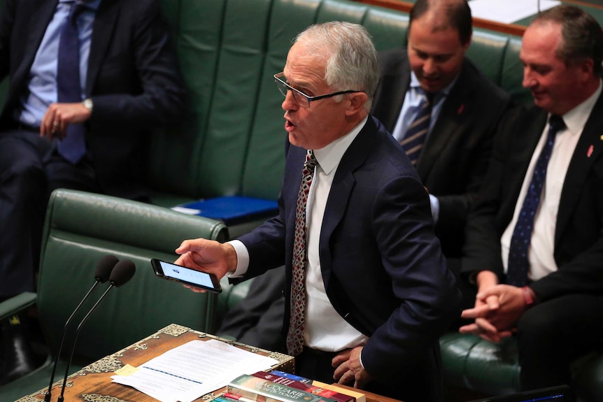 The Prime Minister of Australia hold his phone and speak forcefully to Parliment.