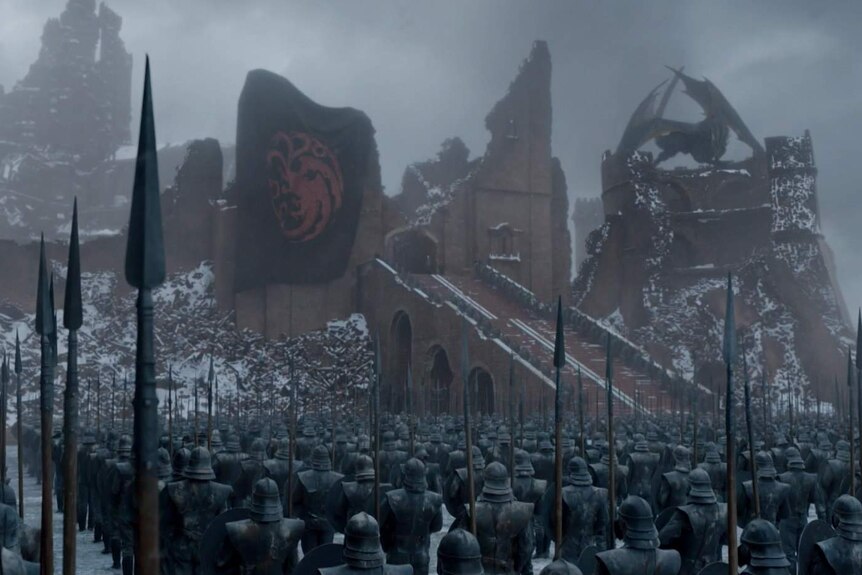 Targaryen banner unfurled on what's left of King's Landing as lines of soldiers watch on.