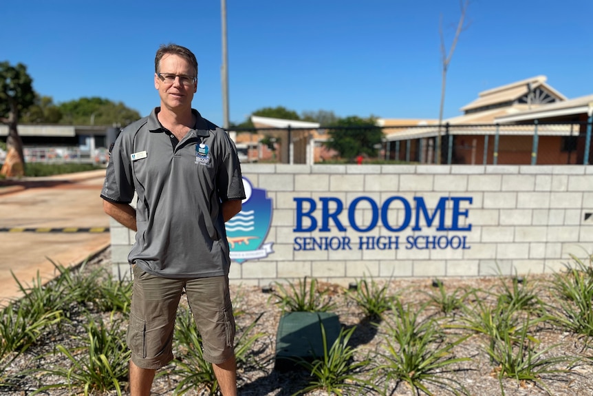 Man stands in front of Broome senior wall 