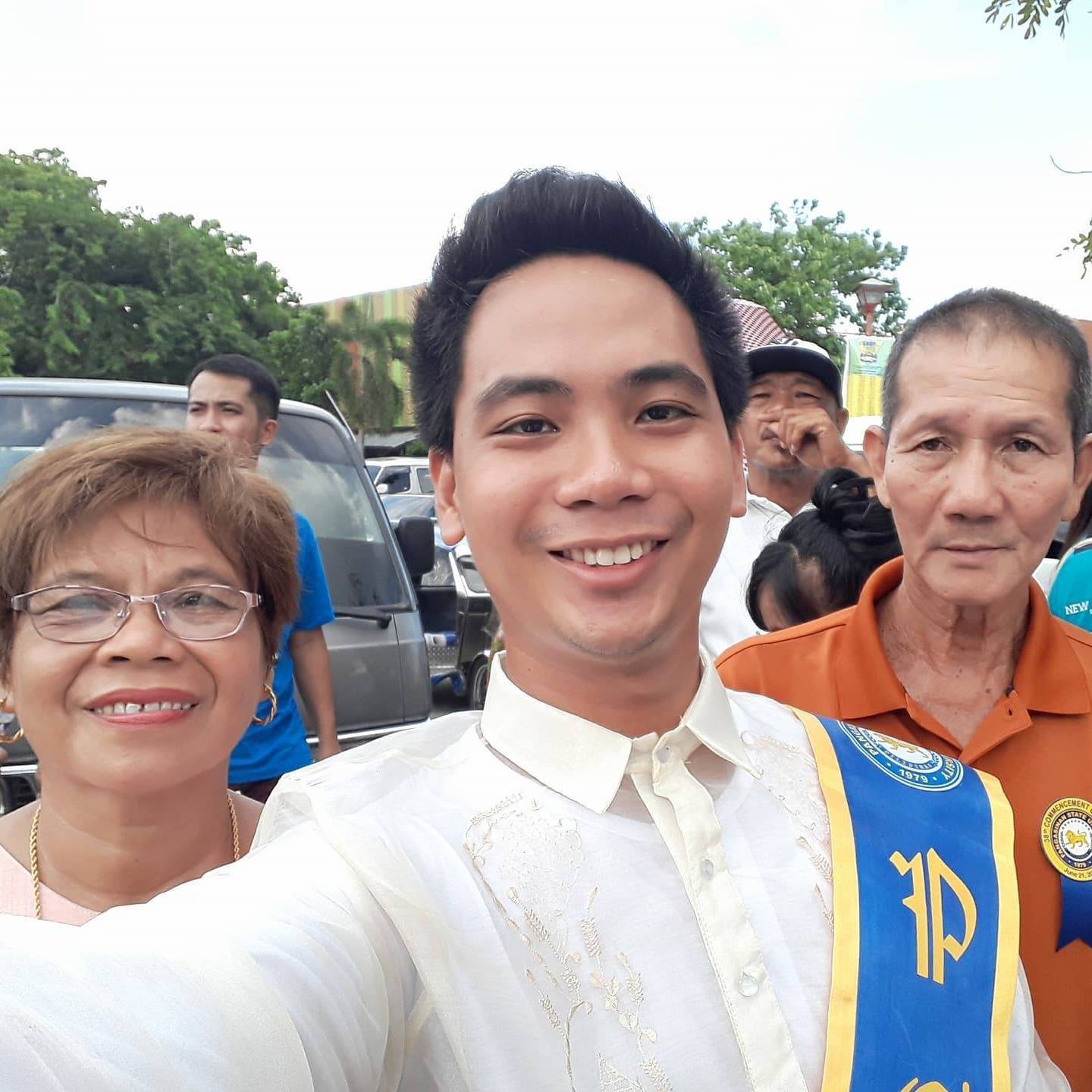 Un joven se interpone entre su madre y su padre. Los tres sonríen.
