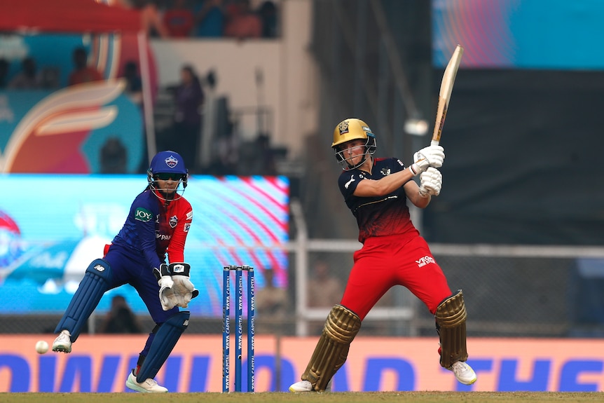 Ellyse Perry bats for the Royal Challengers in their red black and gold kit