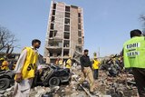 Pakistani rescue workers and police officials examine a bomb blast site in Lahore