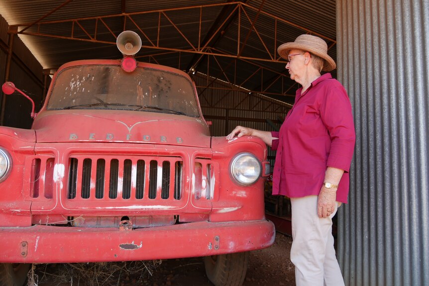 A woman standing in front of an old truck