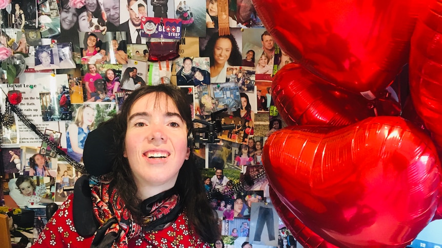 Kim Hopton smiling pictured with red heart baloons.