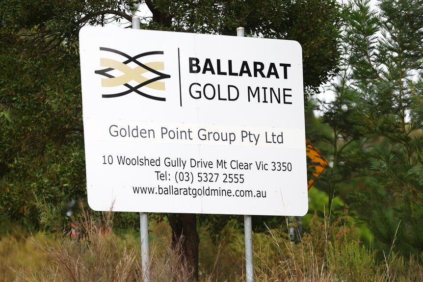 A sign that reads "Ballarat Gold Mine" in a bushy area.