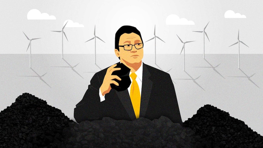 Illustration of man holding piece of coal standing behind mountains of coal with wind turbines in background.
