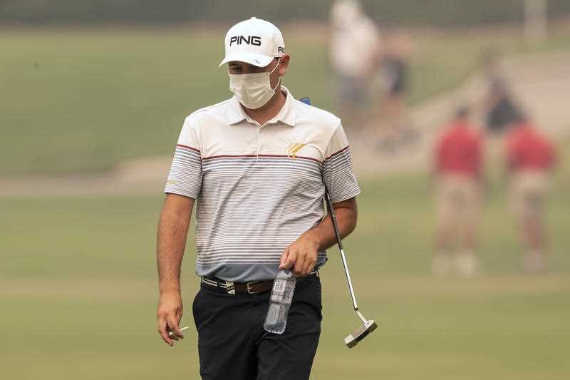 A golfer on a course with a face mask