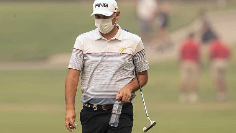 A golfer on a course with a face mask