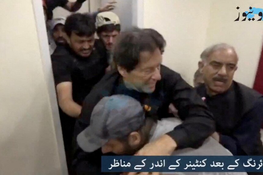 Imran Khan is helped after he was shot in the shin.