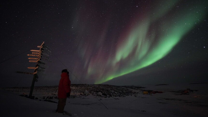 Picture of the night sky with green light through it.