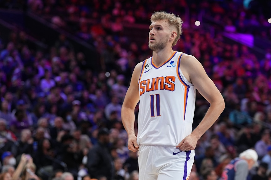 Jock Landale looks defiantly into the crowd wearing a white Phoenix Suns jersey